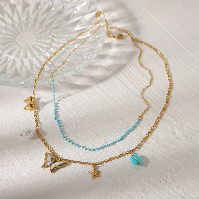 LAYER CON PIEDRAS CELESTES Y DIJE DE MARIPOSA