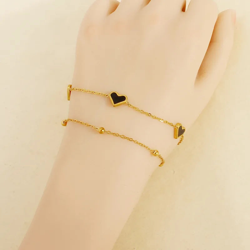 PULSERA DOBLE DE CORAZONES NEGROS CON BALINES DORADO
