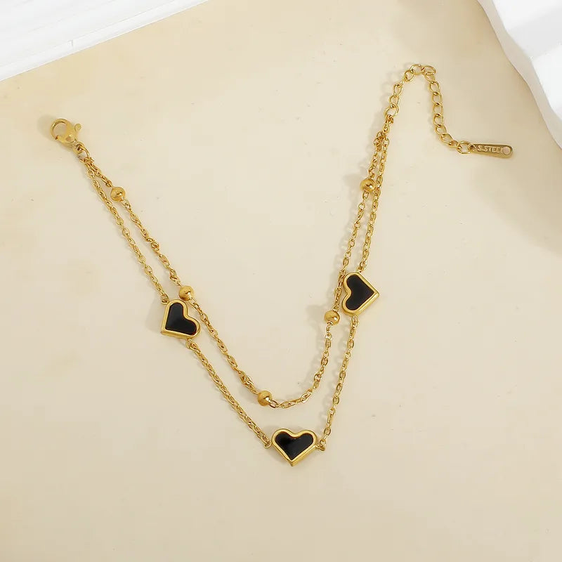 PULSERA DOBLE DE CORAZONES NEGROS CON BALINES DORADO