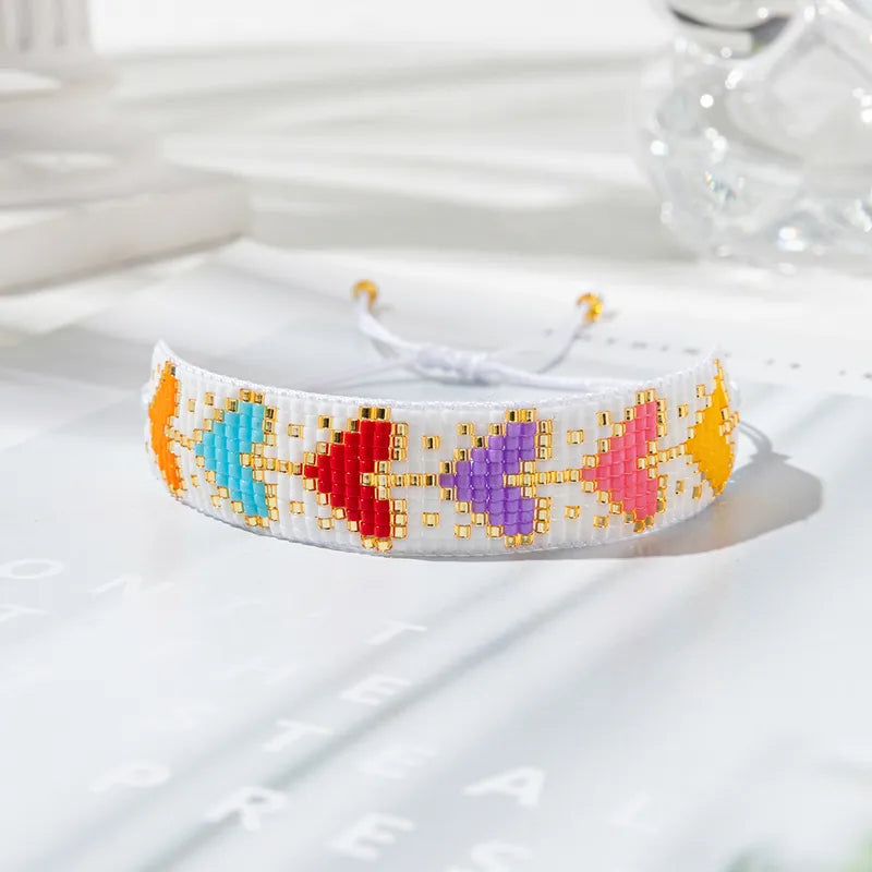 PULSERA CORAZONES COLORES CON TEJIDO MULLOS BLANCOS