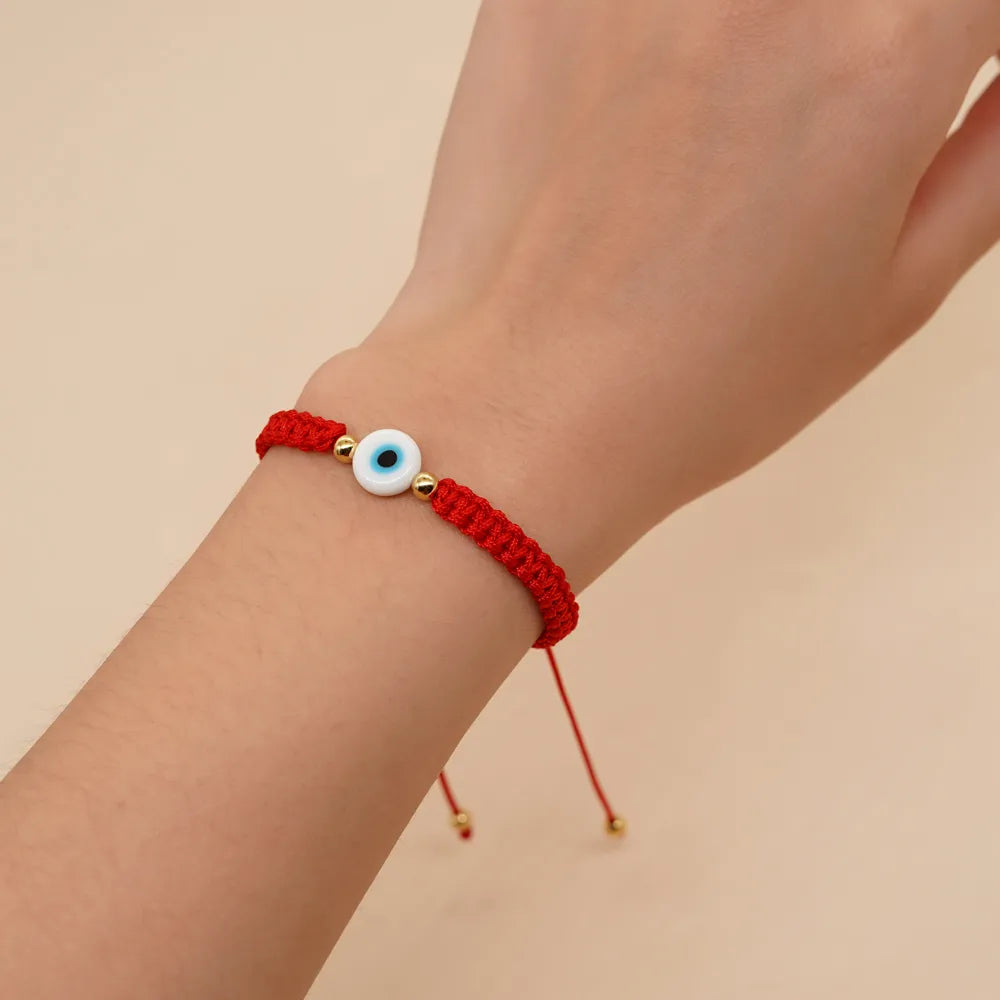 PULSERA HILO ROJO TEJIDO CON OJO BLANCO DORADO