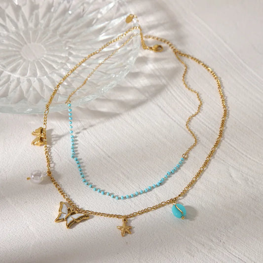 LAYER CON PIEDRAS CELESTES Y DIJE DE MARIPOSA